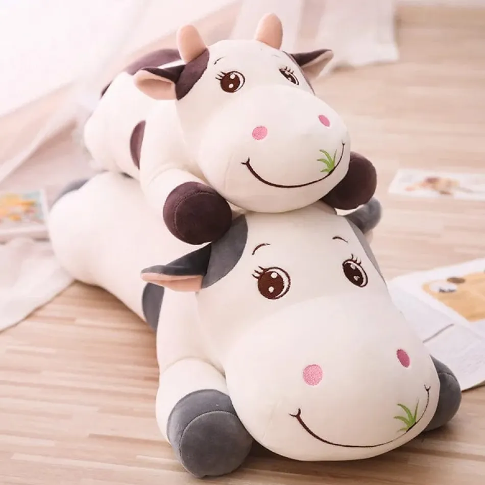 La compagnie de la peluche Peluche vache coloré qui broute de l'herbe