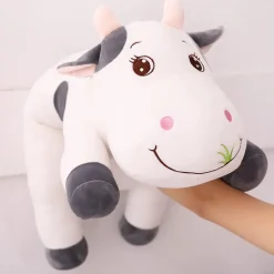 La compagnie de la peluche Peluche vache coloré qui broute de l'herbe