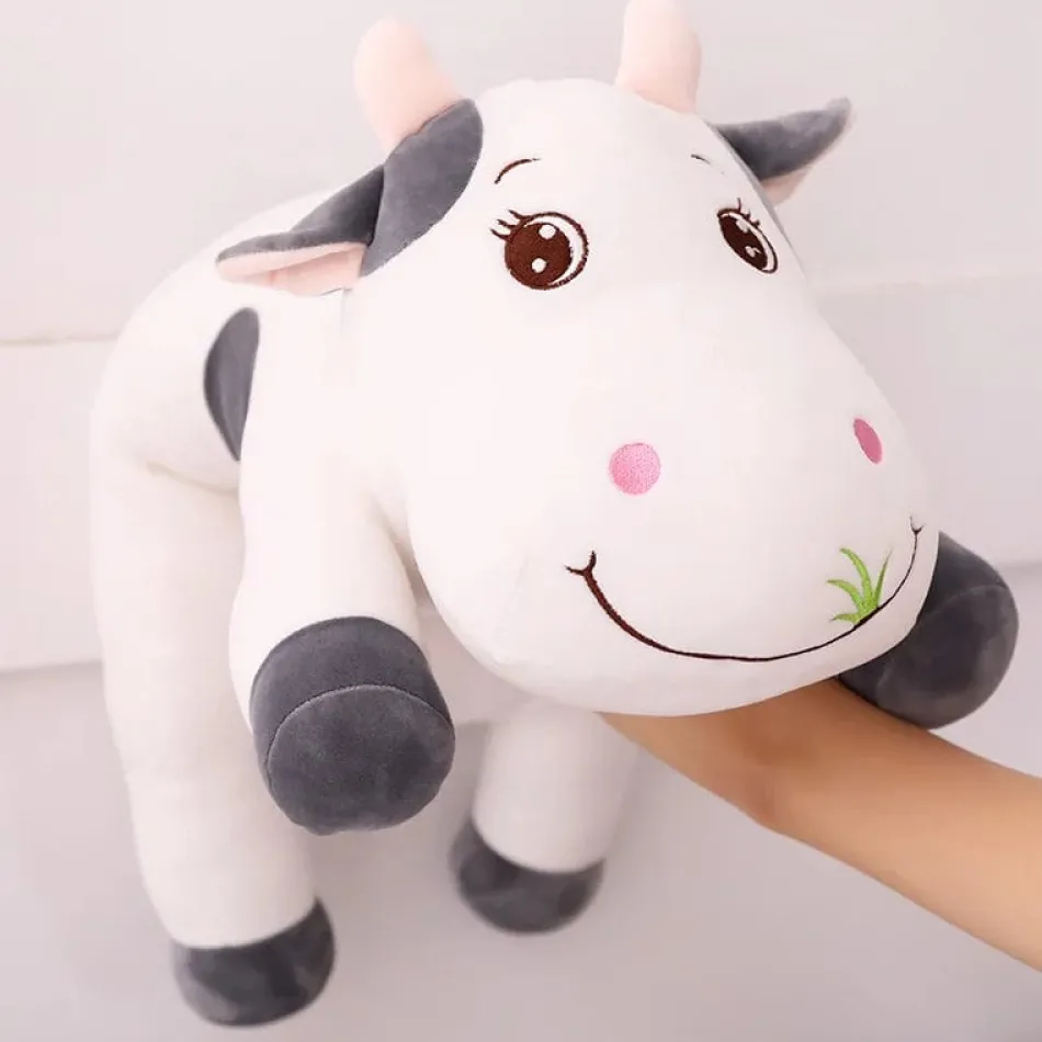 La compagnie de la peluche Peluche vache coloré qui broute de l'herbe