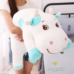 La compagnie de la peluche Peluche vache coloré qui broute de l'herbe